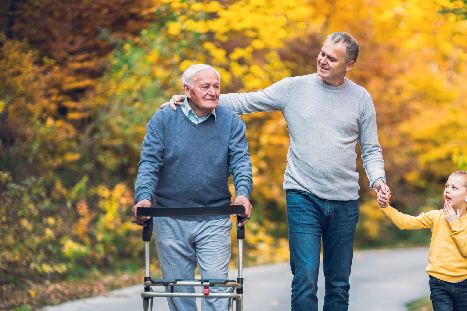 An adult daughter holding hands with her elderly mother