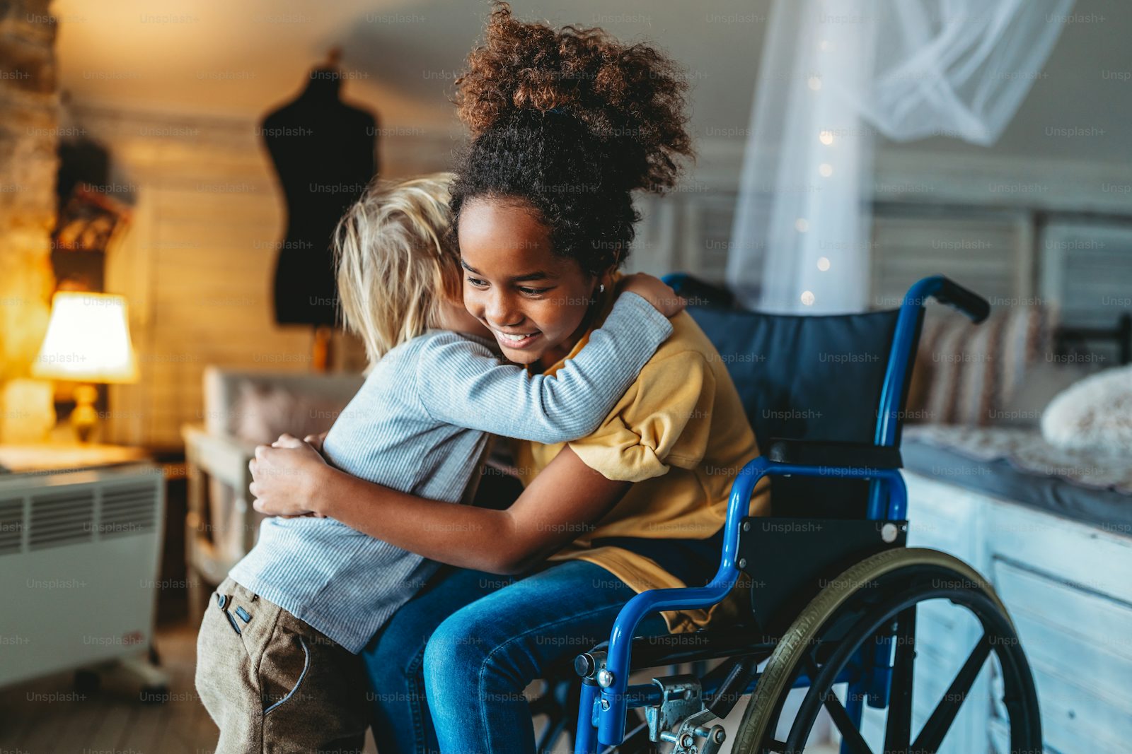 A smiling girl in a wheelchair with her sibling at home